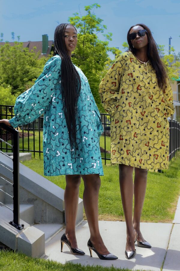 Two women in dresses standing next to each other.