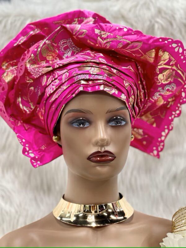 A mannequin wearing a pink head scarf and gold necklace.