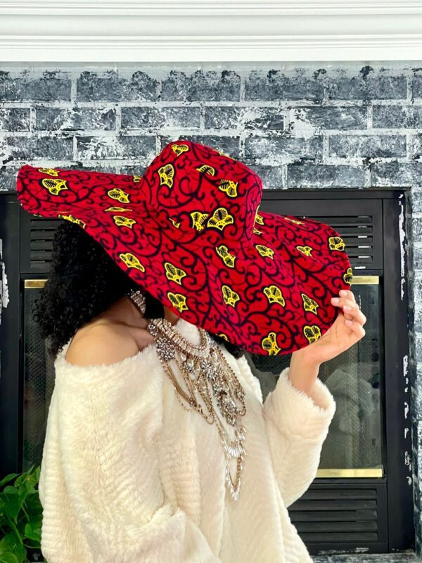 Woman wearing a large red and yellow hat.