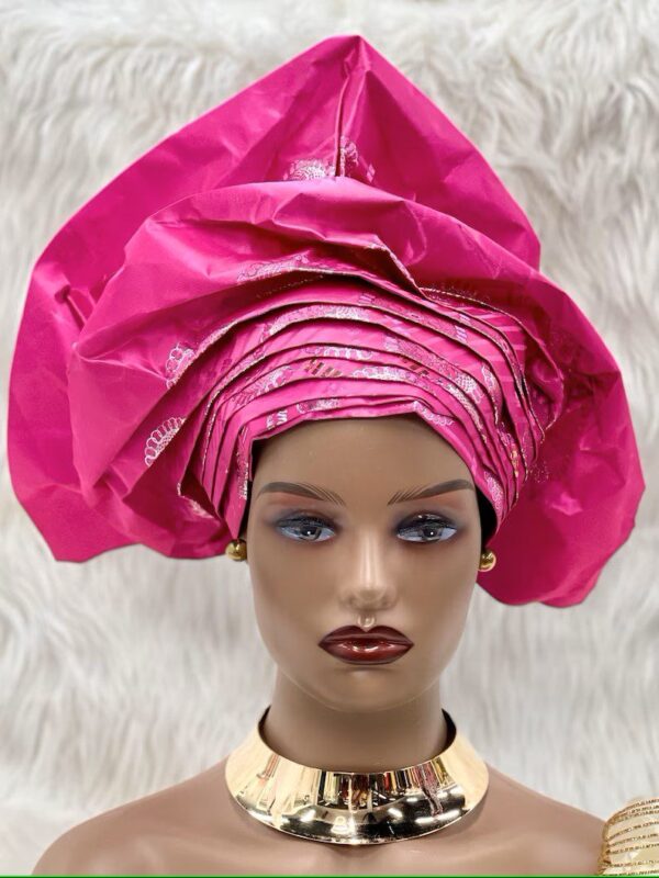 A mannequin wearing a pink head wrap.