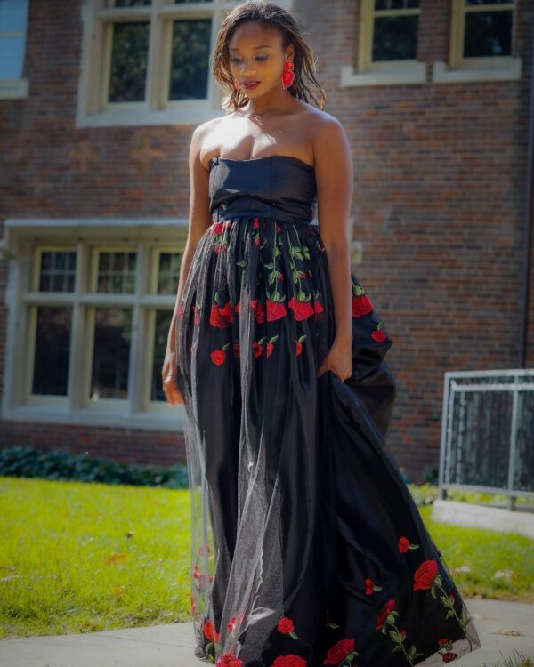 Woman in black dress with red roses.