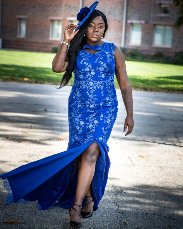 A woman in blue dress walking on the street.