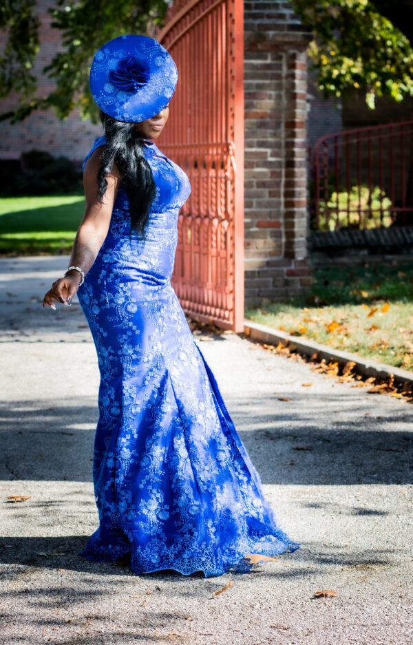 Woman in a blue dress and hat.