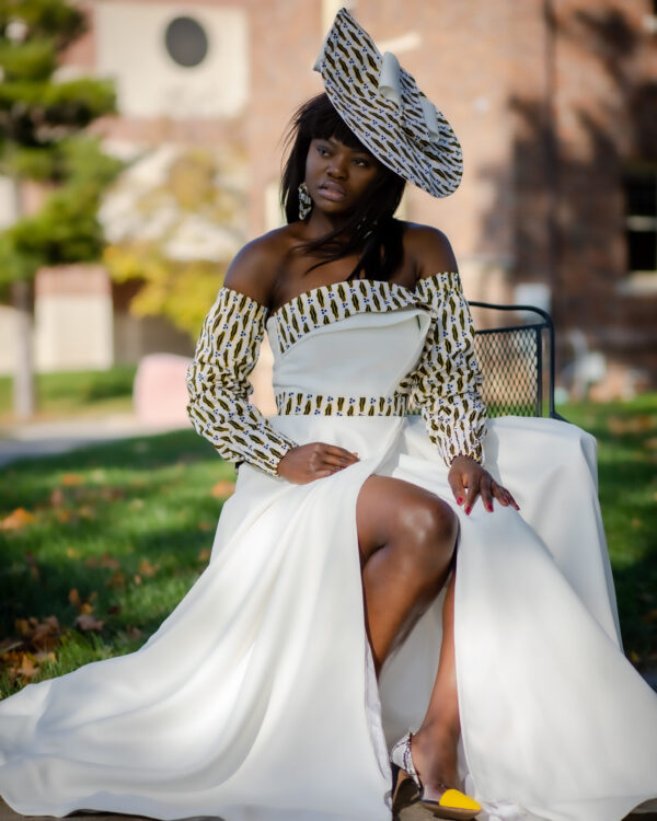 Woman in white dress and patterned hat.