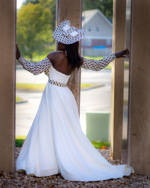 Woman in white dress and patterned hat.