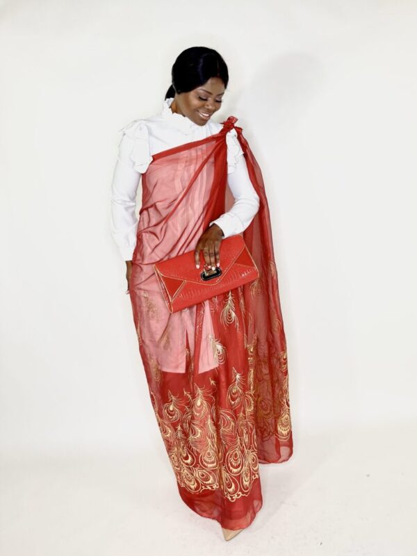 Woman in red dress with gold peacock design.