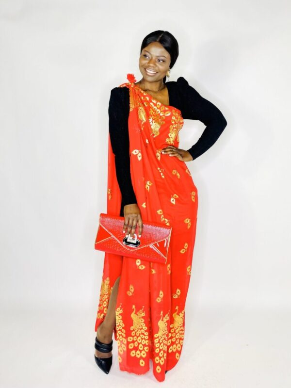 A woman in an orange and yellow dress holding a purse.