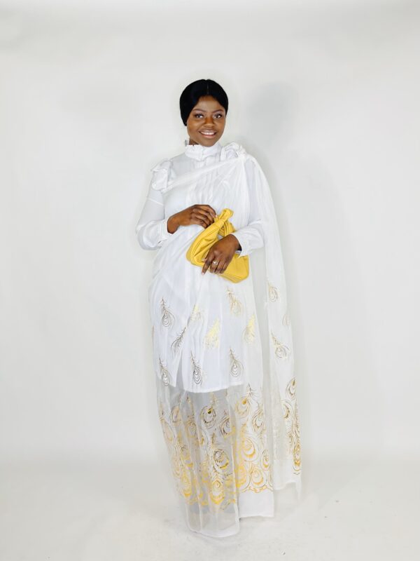 Woman in white dress with gold peacock design.