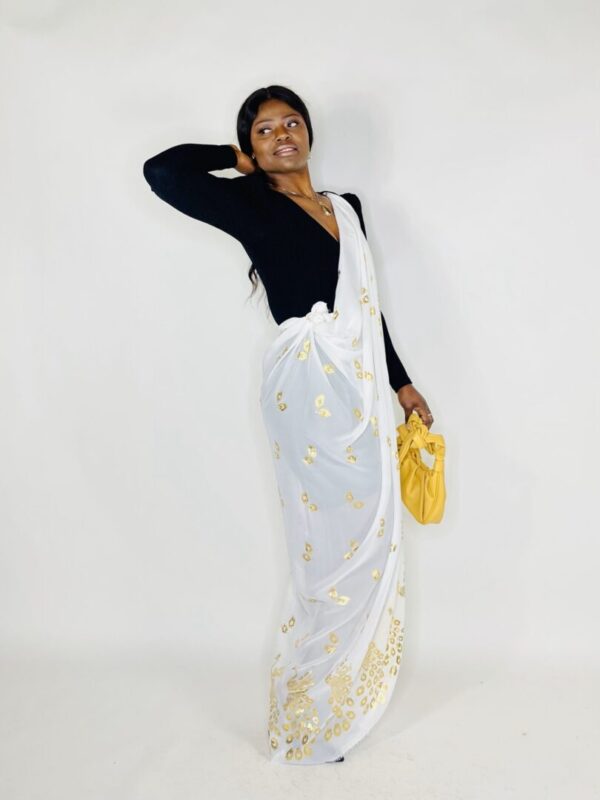 Woman in a white and gold saree.