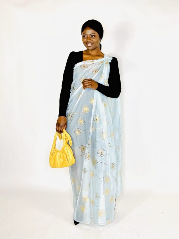 Woman in blue dress with gold dandelions.