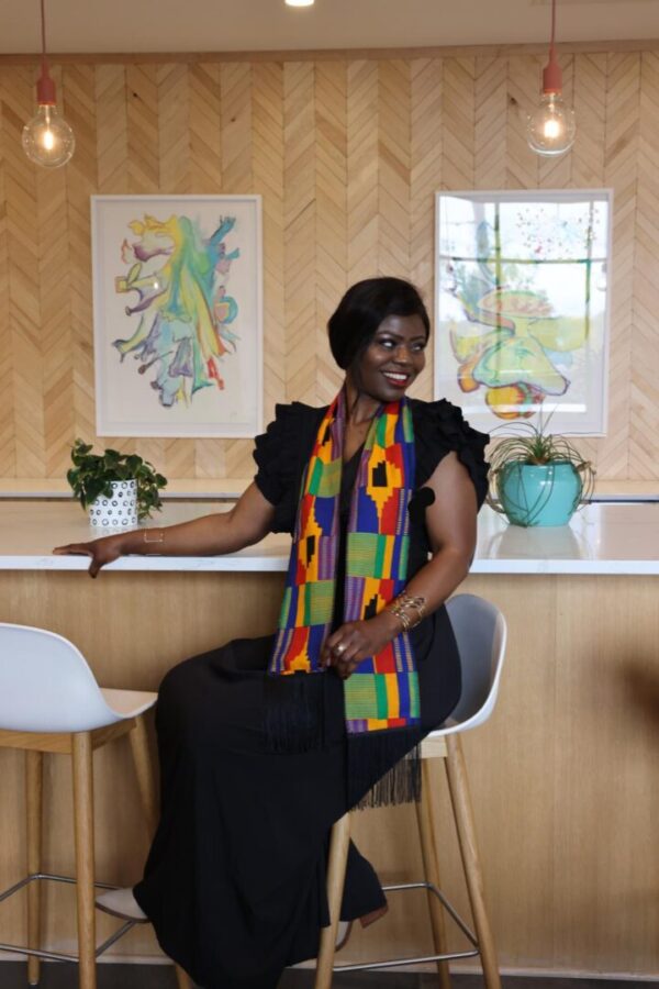 Woman in black dress and colorful scarf.