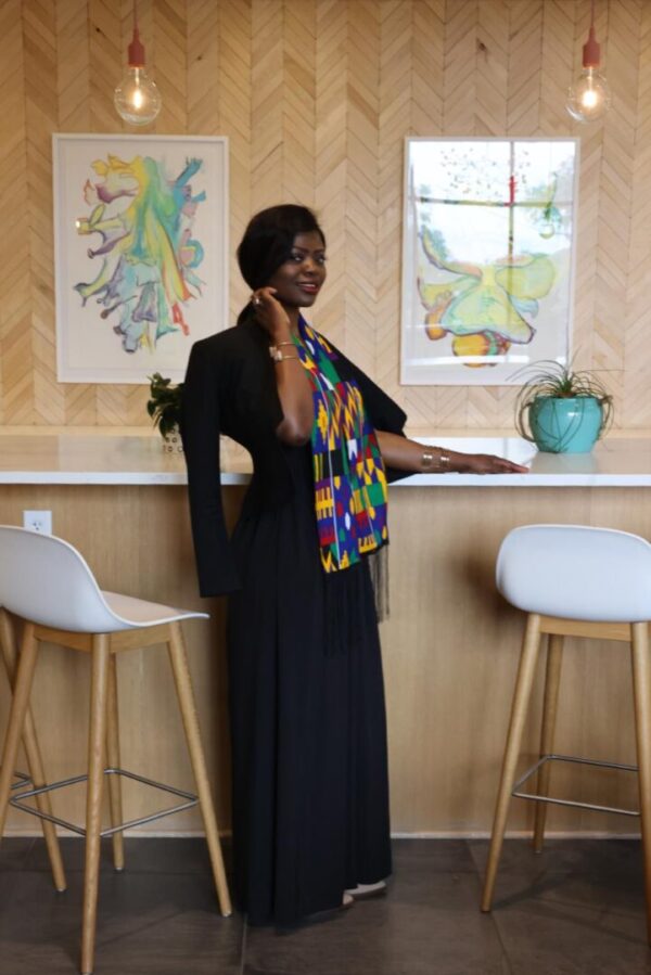 Woman in black dress with colorful scarf.