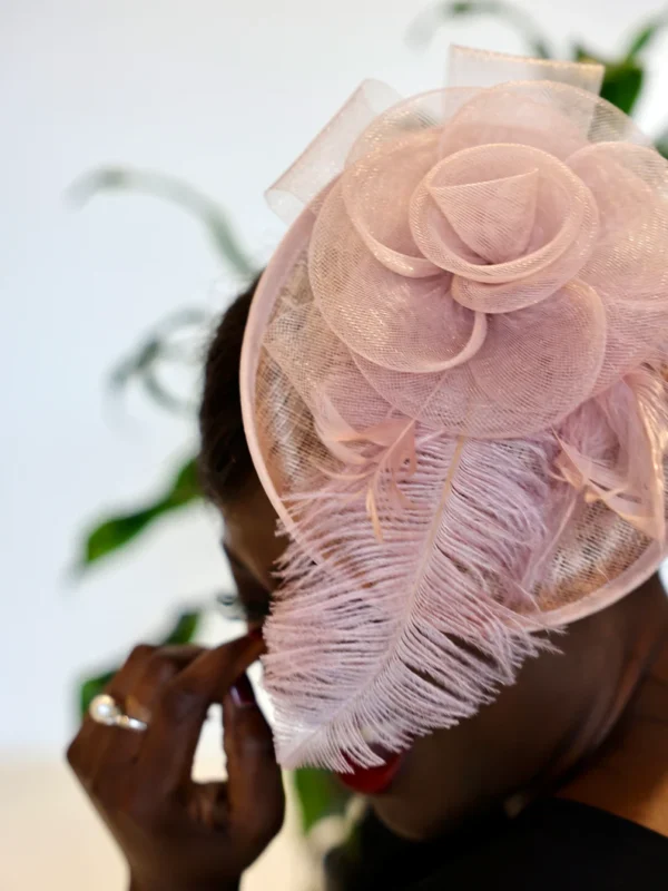 Woman wearing pink feathered hat.