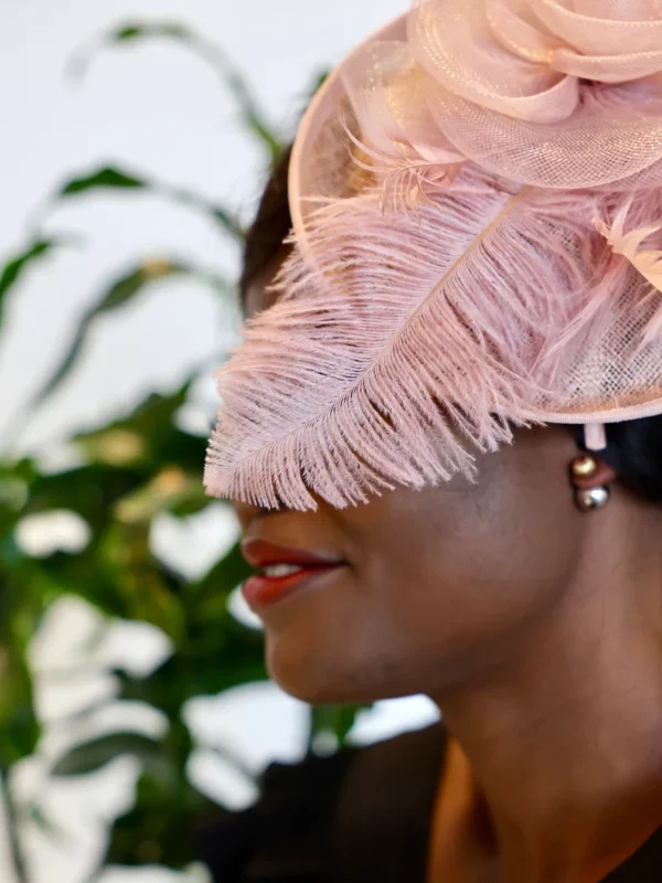 A woman wearing a pink hat and smiling.