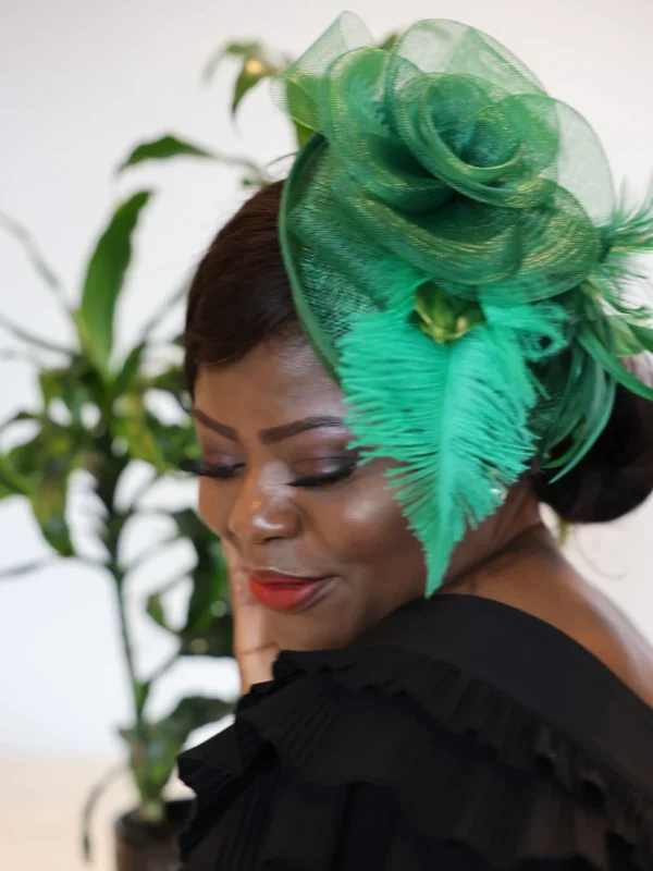 Woman wearing a green feathered hat.