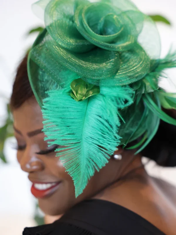 A woman wearing a green hat with feathers.