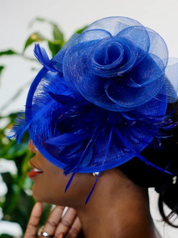 A woman wearing a blue hat with feathers.