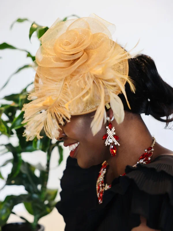 Woman wearing a gold hat and red jewelry.