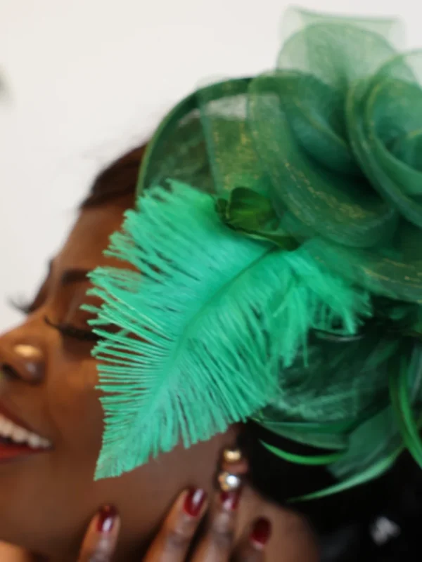 Woman with green feather hat and smile.