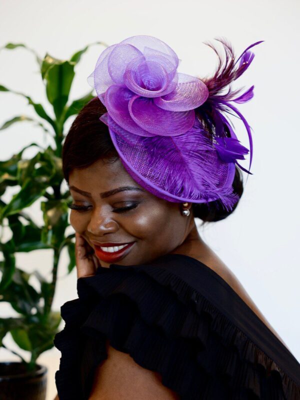 A woman wearing a purple hat and smiling.