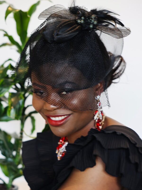 Woman in black veil with red lipstick.