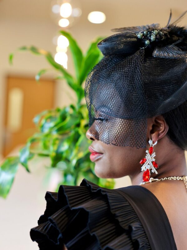 A woman with black hair and a veil on her face.