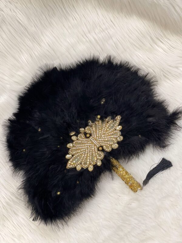 Black feather fan with jeweled embellishment.