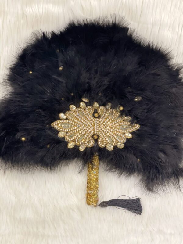 Black feather fan with gold and crystal embellishments.