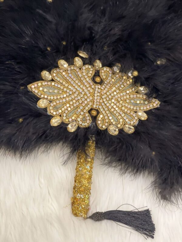 Black feather fan with jeweled embellishment.