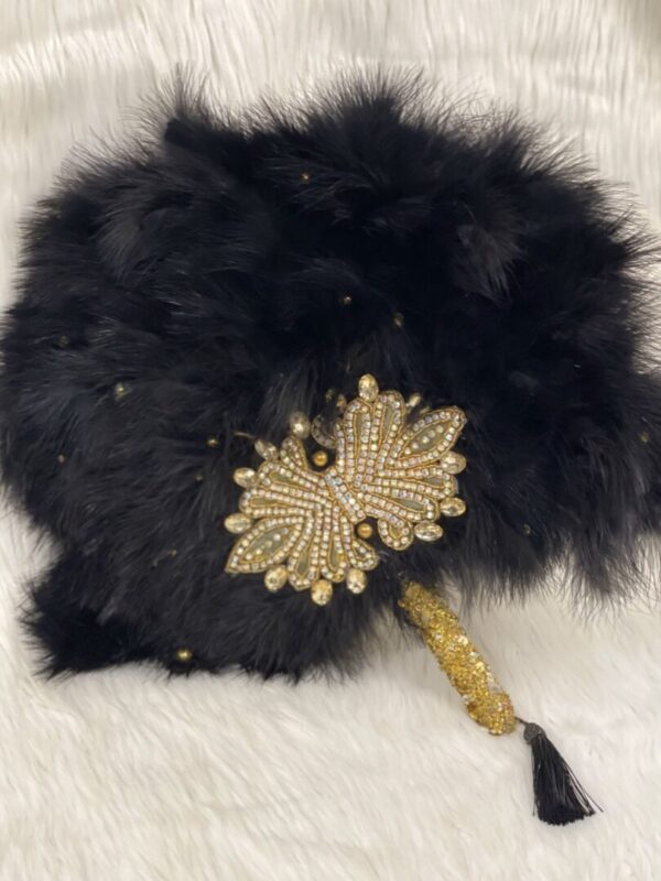 Black feather fan with gold butterfly embellishment.