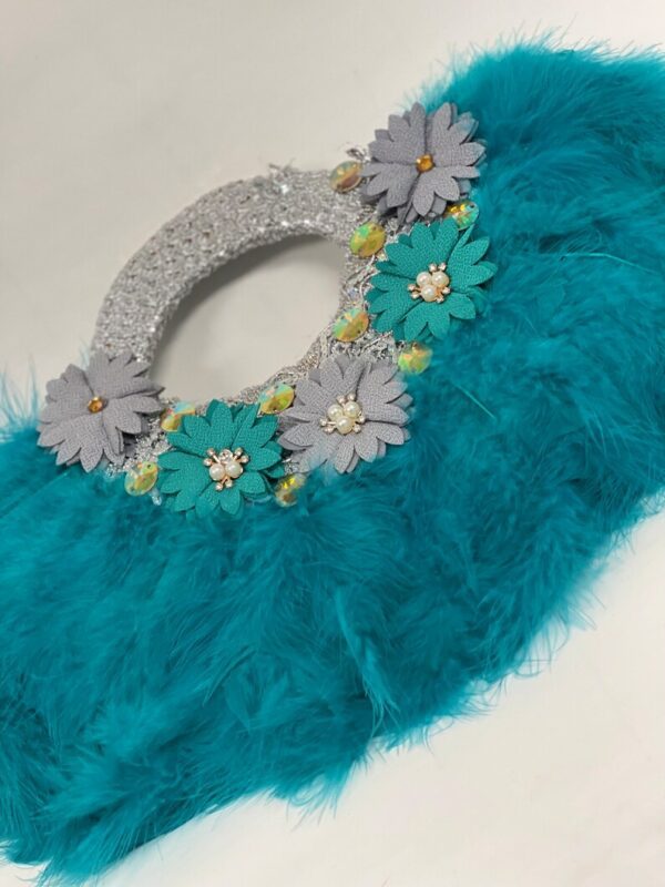 Teal feather clutch with floral embellishments.