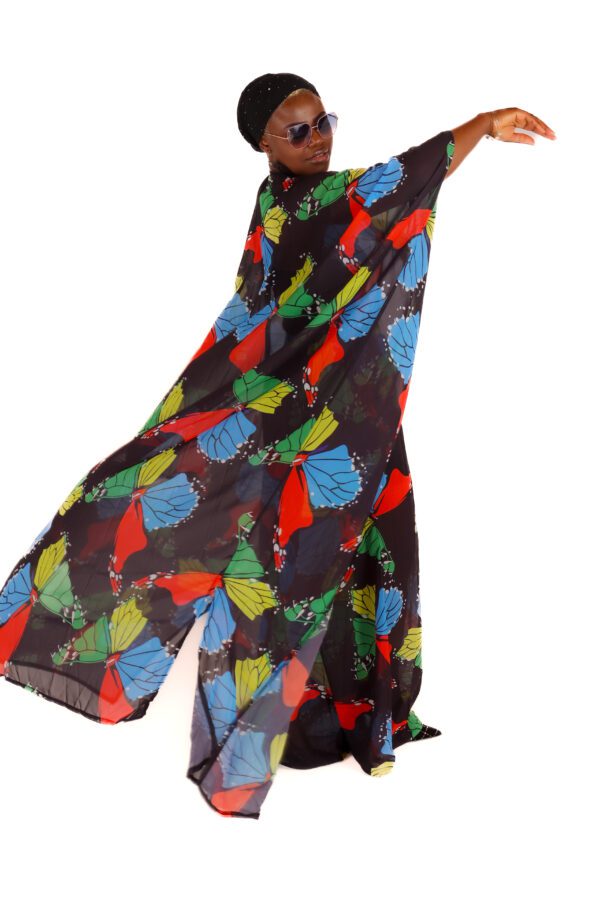 Woman in butterfly print dress posing.
