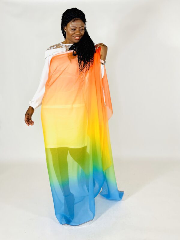 A woman in a rainbow colored dress posing for the camera.