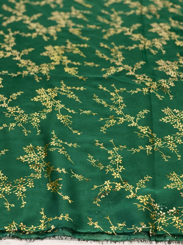 Green fabric with gold floral pattern.