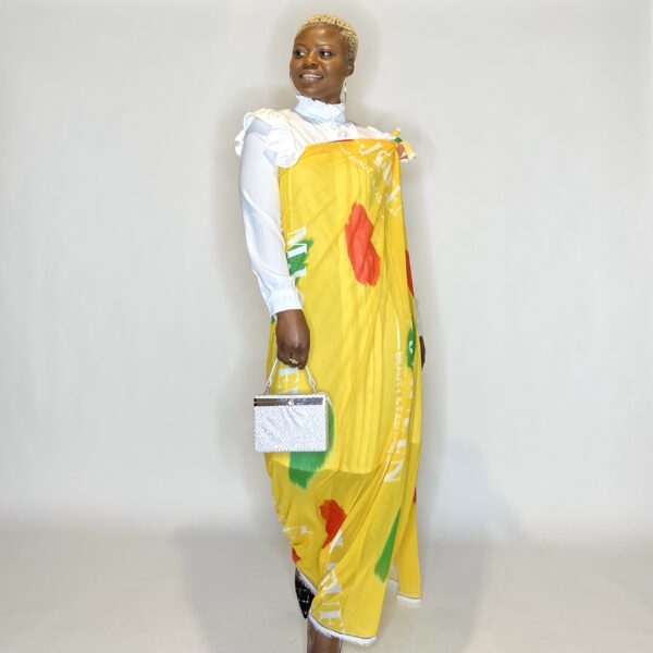 Woman in yellow dress with white shirt and purse.