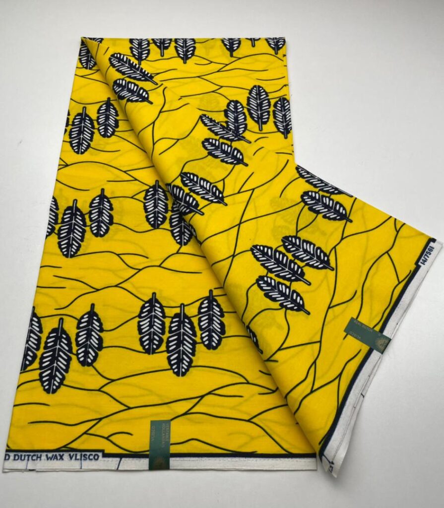 Yellow fabric with black and white leaf pattern.